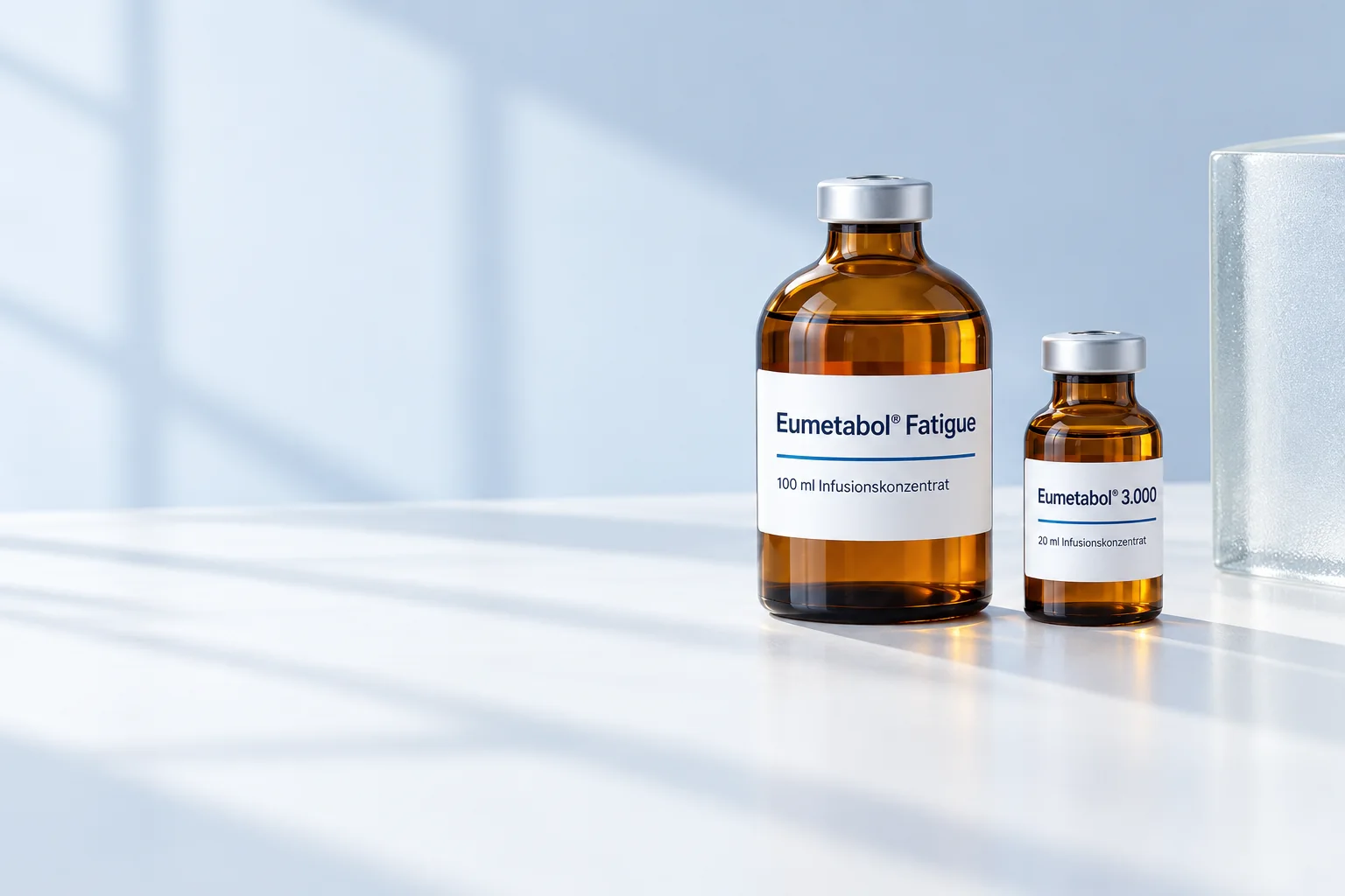 Zwei Eumetabol® Braunglasflaschen im weichen Fensterlicht: Fatigue 100 ml und SAG mono 3.000 mg, 20 ml